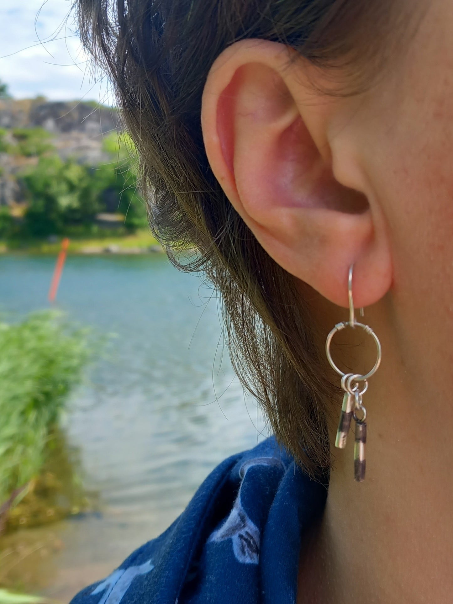 Woman wearing nautical earrings by the seaside