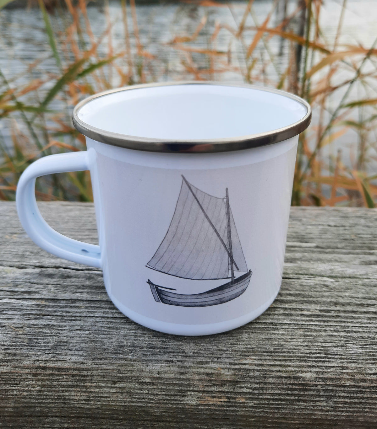 Sprit rigged sailboat mug by the water