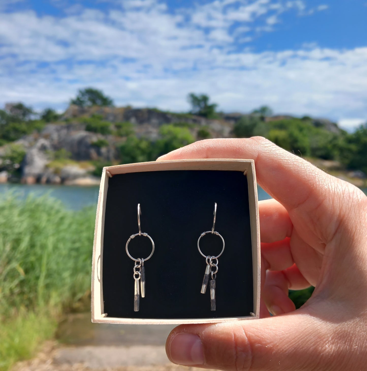 Handmade cardinal buoy earrings in a box by the seaside